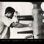 bruce lee doing pak sau punch on wooden dummy.jpg