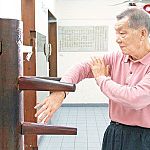 ip ching doing a bong sau technique on a wing chun dummy.jpg