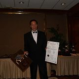 samuel kwok holding his awards